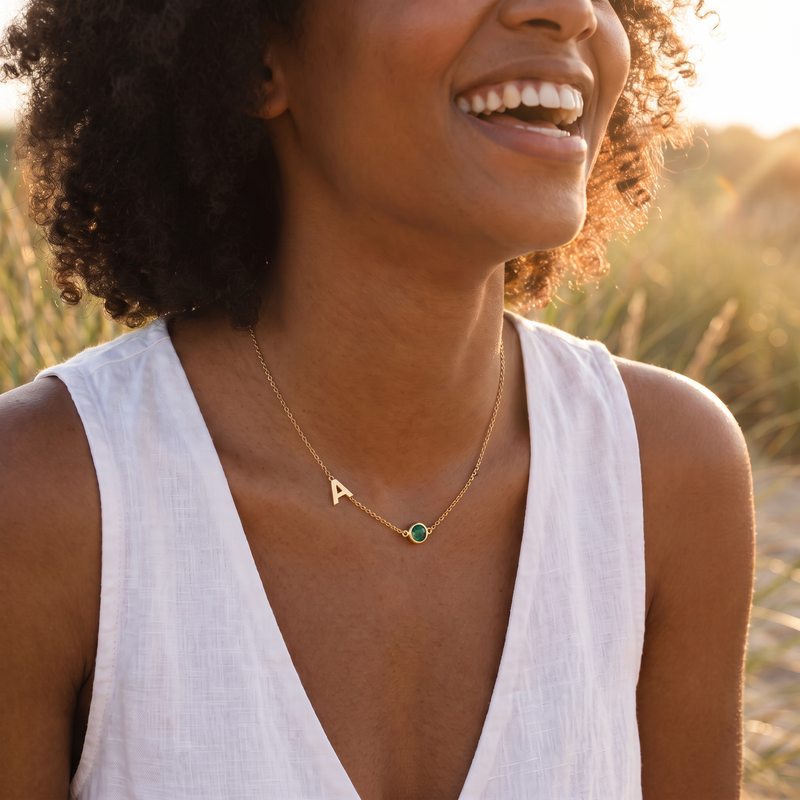 Lachende vrouw in de duinen met de gouden Mira bedelketting