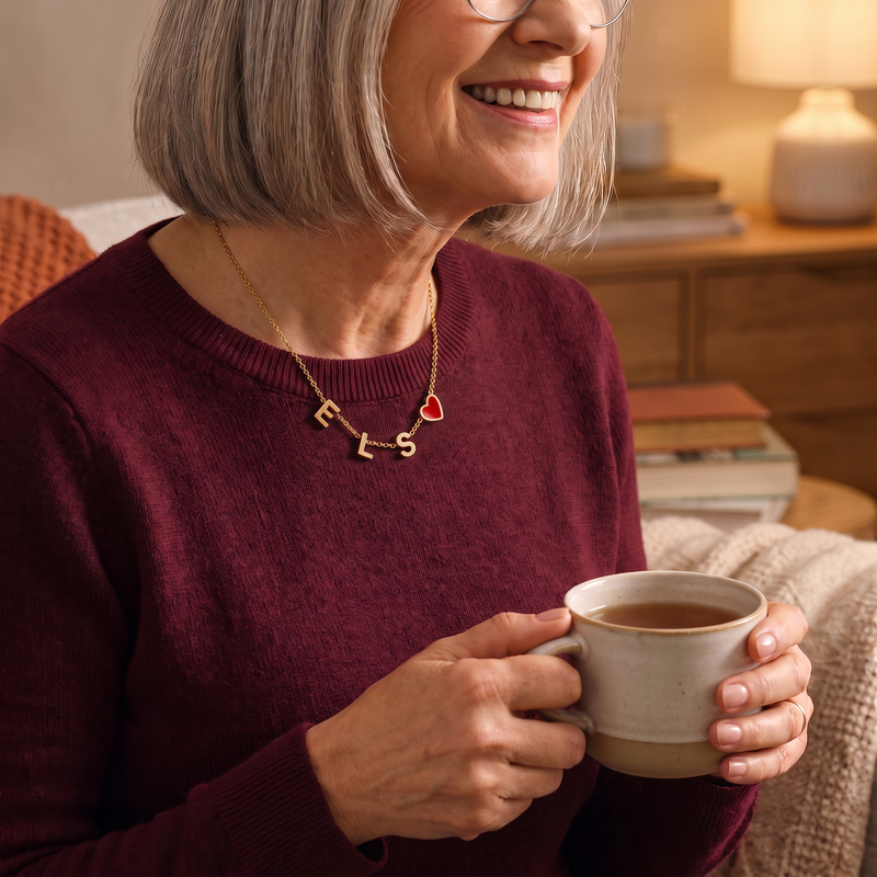 Vrouw met een kop thee die de gouden Mira bedelketting draagt